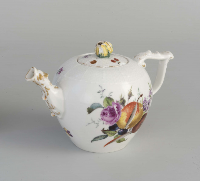 Imbryk kulisty lekko zwężony ku dołowi, wokół wylewu zdobiony plastyczną plecionka w typie Alt-Ozier. Dziobek rurkowy zakończony rozwartym smoczym pyskiem podkreślonym plastycznym liściem akantu. Ucho rokokowe w kształcie litery 