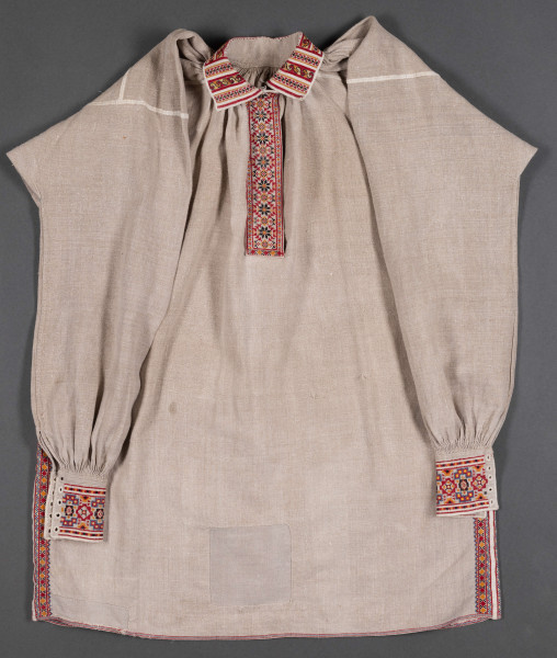 Koszula męska z wykładanym kołnierzem. Wykonana z lnianego płótna. Haftowana nićmi w kolorach: czerwonym, czarnym, żółtym i szafirowym.