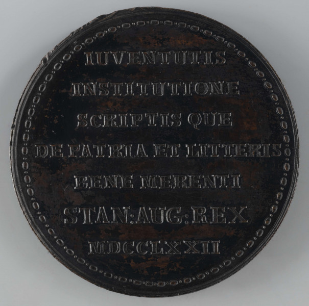 N/2564/ML - AV. Popiersie Karola Wyrwicza w profilu w prawo, z odkrytą głową. W otoku napis rozdzielony na dole przez kompozycję:
CAROL:WYRWICZ RECTOR COL:NOB:WARS:SOC:IES:
Sygnatura: I.P.HOLZHAEUSSER.F.

RV. Siedmiowierszowy napis:
IUVENTUTIS / INSTITUTIONE / SCRIPTIS QUE / DE PATRIA ET LITTERIS / BENE MERENTI / STAN:AUG:REX / MDCCLXXII
Całość ujęta otokiem z perełek o dwóch wielkościach.