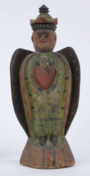 E/8100/ML - Rzeźba pełna wykonana z jednego kawałka drewna lipowego, polichromowana. Postać w hieratycznej postaci, w układzie frontalnym. Ręce wsparte na biodrach. Postać stoi na stożkowatym cokole. Na głowie korona z dwóch oddzielnych kawałków drewna, złączonych ozdobnym czopem drewnianym. Włosy czarne, ręce i twarz różowa, korona żółta z czerwonym obrzeżem, zwieńczenie czarne. Płaszcz stylizowany, przypominający skrzydła lub ornat, czarny. Szaty wewnętrzne żółte z czerwonymi plamkami. Wewnątrz długie, zielone z niebieskimi plamami. Buty czarne. Na piersiach duże otwarte serce zwieńczone czarnym krzyżem. Cokół w naturalnym kolorze drewna, ozdobiony pionowymi niebieskimi paskami i czerwonymi kropkami. Wym. cokołu: 13 x 10,5 cm. Sygnatura na spodzie (pisana): Jan Kaproń.