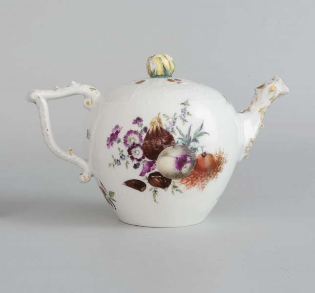 Imbryk kulisty lekko zwężony ku dołowi, wokół wylewu zdobiony plastyczną plecionka w typie Alt-Ozier. Dziobek rurkowy zakończony rozwartym smoczym pyskiem podkreślonym plastycznym liściem akantu. Ucho rokokowe w kształcie litery 