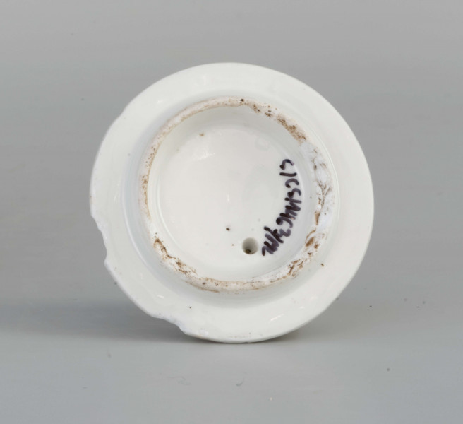 Imbryk kulisty lekko zwężony ku dołowi, wokół wylewu zdobiony plastyczną plecionka w typie Alt-Ozier. Dziobek rurkowy zakończony rozwartym smoczym pyskiem podkreślonym plastycznym liściem akantu. Ucho rokokowe w kształcie litery 