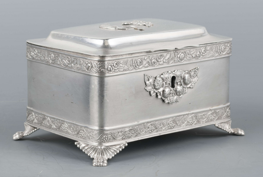 S/Mt/354/ML - Cukiernica prostokątna o lekko zaokrąglonych narożach, na czterech nóżkach w formie uskrzydlonych lwich łap, z profilowanym wieczkiem. Brzegi obwiedzione moletowaną taśmą: u dołu z motywem winnej łozy, u góry - wici różanej.Szyld zamka zdobi plakieta z girandą róż, druga - na wieczku - jest uszkodzona a przez to nieczytelna.
Na dnie sygnatury kursywa we wklesłych owalnych ramkach:
- K.Rotkiel
- w lublinie
Przedzielone okrągłą puncą z próbą 