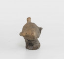 Figurka zoomorficzna w kształcie ptaszka, wykonana schematycznie. Nóżka walcowata. Główka, ogon oraz skrzydełka ledwie zaznaczone. Powierzchnia gładzona niestarannie. Sklejone, uzupełnione gipsem. Surowiec - glina z domieszką drobnoziarnistą. Barwa Szarobrunatna. Wypał dobry.
Wymiary dodatkowe: 1,3 cm (śr. stopki), 2,4 cm (rozstaw skrzydełek)