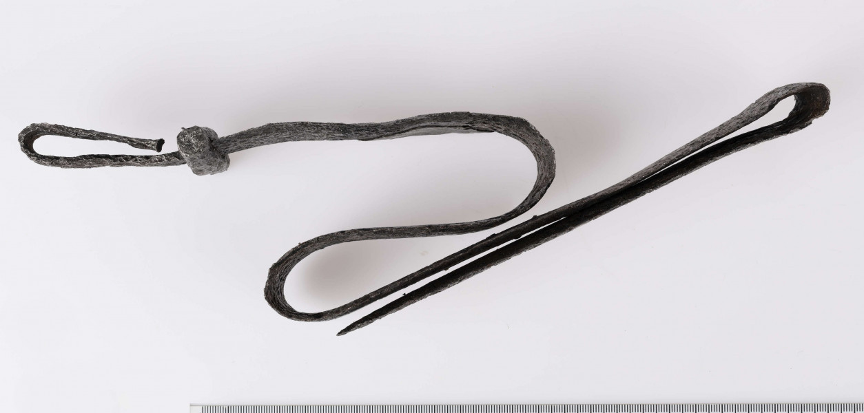 Miecz żelazny, obosieczny, bez strużyn. U podstawy trzpienia znajduje się krótki, prosty w przekroju czworoboczny jelec. Kolec prosty na końcu rozklepany. Miecz rytualnie zgięty.