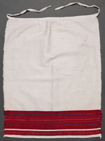 Fartuszek lniany ozdobiony u dołu haftem tkackim, zw. perebory w kolorze czerwono-granatowym.