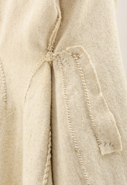 Sukmana kobieca, odświętna, szyta ręcznie z samodziałowego, folowanego sukna w kolorze białym. Nieodcinana w talii, przody bez zapięcia. Rękawy długie, lekko zwężone ku dołowi. Na bokach poniżej talii wstawione trójkątne kliny, które tworzą fałdy. W szwach łączących przody z klinami – tzw. ślepe kieszenie. Ozdobiona czerwonym i granatowym sznureczkiem wełnianym: na kołnierzyku, na przodzie,  dole rękawów oraz na bokach poniżej talii i przy kieszeniach. Często przepasywana była wełnianą krajką.