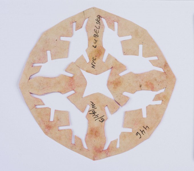 Wycinanka różowa w formie wieloboku z gwiazdą czteroramienną ażurowaną w centrum. Dookoła poczwórny motyw grzybków.
