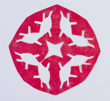 Wycinanka różowa w formie wieloboku z gwiazdą czteroramienną ażurowaną w centrum. Dookoła poczwórny motyw grzybków.
