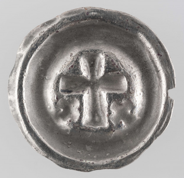 N/2940/ML - Krzyż łaciński o lekko rozszerzających się końcach ramion. Na dole, z obu stron dłuższego ramienia krzyża, krzyżyki ukośne.