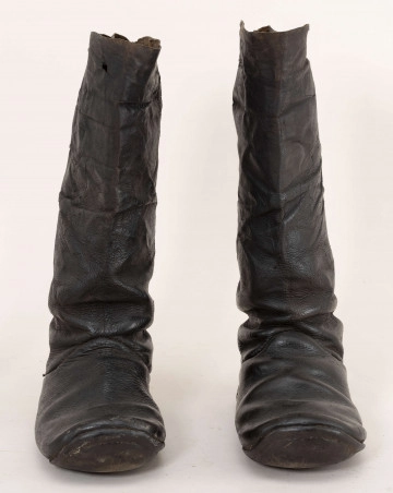 Buty skórzane wykonane w Tyszowca z cholewami. Nosy okrągłe, podwinięte, obcas 2,8 cm, podbity podkówką metalową. Wysokość zapiętka 8,5 cm., wysokość cholewy 37,5 cm. Nad kostką cholewy układają się w fałdy.