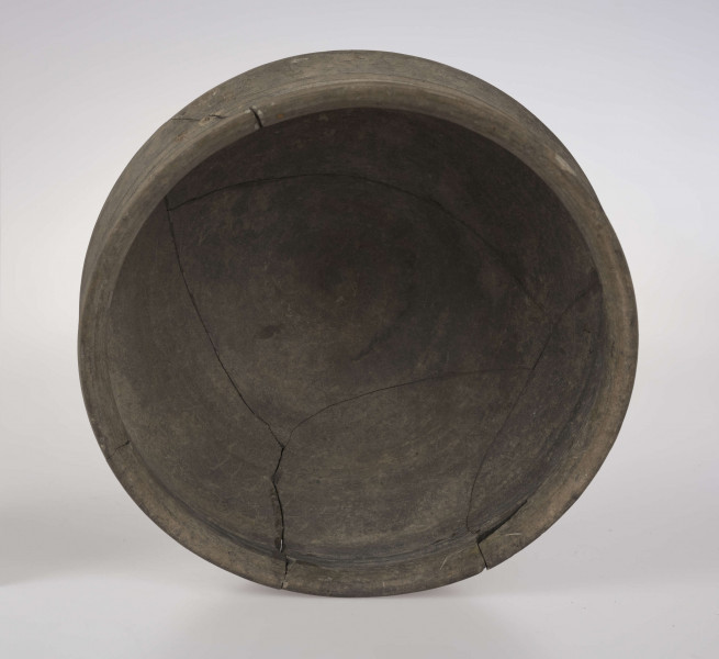 Naczynie o wklęsłym dnie, z dołkiem w centralnej części. Dno wyodrębnione niewysoką stopką. Brzusiec łagodnie profilowany. Szyjka podkreślona plstyczną listwą, w części środkowej nieco wypukła. Krawędź wylewu delikatnie wywinięta na zewnątrz. 