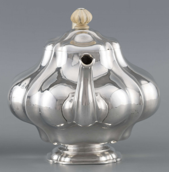 S/Mt/500/ML - Korpus silnie wybrzuszony w części środkowej, puklowany pionowo, profile przechodzą na pokrywke w formie wieczka na zawiasie. Stopa kwadratowa wielolistna, wylew w formie dzióbka, ucho kościane osadzone w dwóch tulejkach,
uchwyt na pokrywce kościany, profilowany. Wnetrze złocone.
Na spodzie stopy sygnatura:
- 