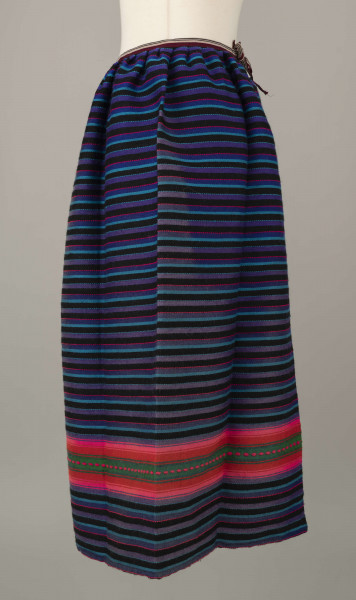 E/6813/ML - Fartuszek wełniany tkany w kolorowe wąskie pasy w kolorze: granatowym, niebieskim, fioletowym, czarnym i amarantowym z szerokim pasem o wiązce kolorystycznej: amarantowy, czerwony, zielony. Przymarszczony i wszyty w płócienny pasek z troczkami.