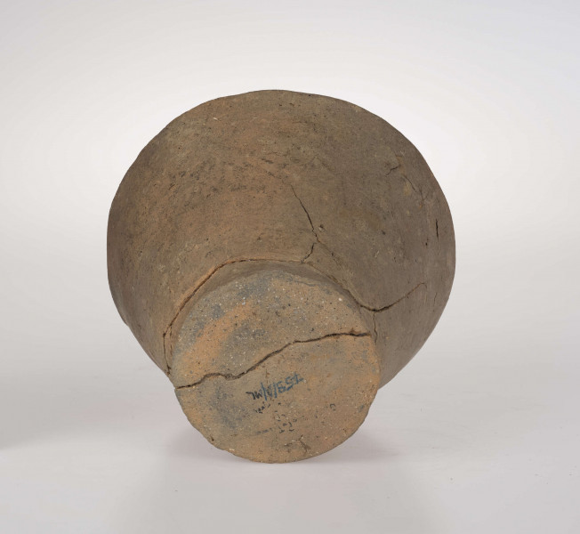 Dzban ostro profilowany, z prostym, odgiętym na zewnatrz brzegiem podkreślonym rowkiem, ostro zaznaczonym załomem brzuśca i wyodrębioną stopką. Ucho dzbana jest taśmowate, kolankowato zgięte, z przewierconym kanalikiem. Ponad załomem brzuśca naczynie zdobione jest ornamentem blankowym, który tworzy para równolegle rytych linii wypełnionych dołkami. Całość ujęta górą i dołem w wątek linii rytej i rzędu dołków. 
