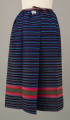 E/6813/ML - Fartuszek wełniany tkany w kolorowe wąskie pasy w kolorze: granatowym, niebieskim, fioletowym, czarnym i amarantowym z szerokim pasem o wiązce kolorystycznej: amarantowy, czerwony, zielony. Przymarszczony i wszyty w płócienny pasek z troczkami.