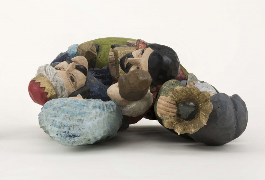 Rzeźba z drewna lipowego, technika strugania, polichromowana farbami plakatowymi. Na postumencie w kształcie nieregularnego owalu o wym. 23 x 13 x 1,5 cm, w kolorze seledynowym, zakomponowane zostały cztery postacie. W głębi z lewej strony postać króla (wys. 38 cm) w granatowej długiej szacie i zielonym płaszczu, z okrągłym kołnierzem. Król w lewej podniesionej ręce trzyma złotą koroną, w prawej – srebrny dzbanek. Z prawej strony postać Matki Boskiej (wys. 38,5 cm) z Dzieciątkiem (wys. 17 cm) w kremowej sukience, na prawym ręku. MB w czerwonej długiej sukni, zielonym płaszczu i niebieskiej chustce na głowie. Przed MB z lewej strony klęczy król (wys. 24,5 cm) w czerwonym płaszczu i czarnej sukni, który w rękach trzyma złotą szkatułkę. Z prawej strony klęczy król (wys. 28,5 cm) w granatowym płaszczu o niebieskim podbiciu i mankietach, brązowych spodniach, granatowych butach sięgających do połowy łydki. Na głowie ma złotą koronę na czerwonej czapce, otoczonej białym zawojem. W lewej ręce trzyma złotu kielich. 