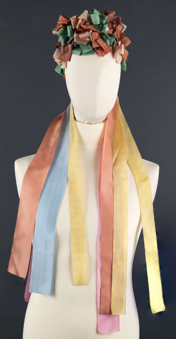 E/5038/ML - Strój głowy panny młodej wykonany jako rekonstrukcja. Wianek z papieru obszytego białym płótnem fabrycznym.  Z  wierzchu naszyte kolorowe wstążki poskładane i pozszywane na krzyż. W tyłu doszyte długie kolorowe wstążki, koloru: czerwonego, różowego, zielonego i niebieskiego.  