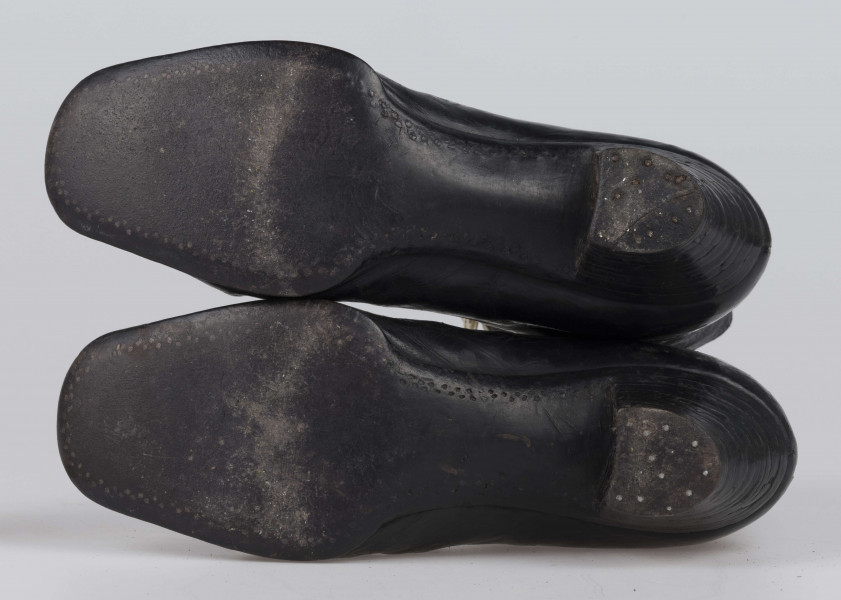 E/11811/ML - Buty odświętne, z czarnej licowej skóry. Wewnątrz płócienna podszewka. Obcas słupowaty wys. 5 cm. Podeszwy ze skóry. Cholewka wys. 10 cm, dopasowana do nogi, z przodu sznurowana. Nosek zwężony, na końcu ścięty. Wykrój podeszew w obu butach identyczny – lewy równa się prawemu.