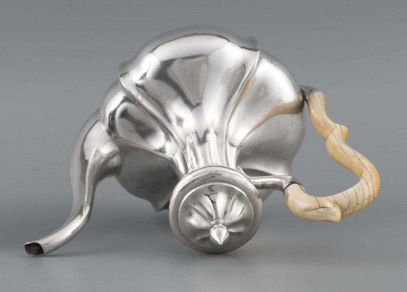 S/Mt/514/ML - Kafetiera w kształcie tralki o brzuscu pękatym i smukłej szyjce, profilowana a żeberkowaniem, na niskiej stopie. Wylew w formie dziobka, ucho kościane z okrągłego wałka, profilowane, osadzone w dwóch tulejkach, pokrywka wysklepiona, z wystającą kryzą i uchwytem w kształcie cebulki. Wnetrze złocone.
Na dnie sygnatura:
- imienna 