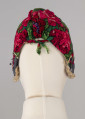 E/8141/ML - Czepek mężatki na płóciennej podszewce z zielonej cienkiej wełenki w amarantowe róże, fioletowe sasanki i jasnozielone listki. Marszczony na środku przodu i tyłu. Przód ozdobionymi kremowymi i granatowymi ząbkami, srebrną metaliczną wstążką oraz szeroką atłasową wstążką w kolorze granatowym w białe i czerwone kwiaty. Brzeg wykończony białą tiulową, drobno plisowaną kryzą. Przód wycięty w duży ząb w kształt płatka kwiatu.