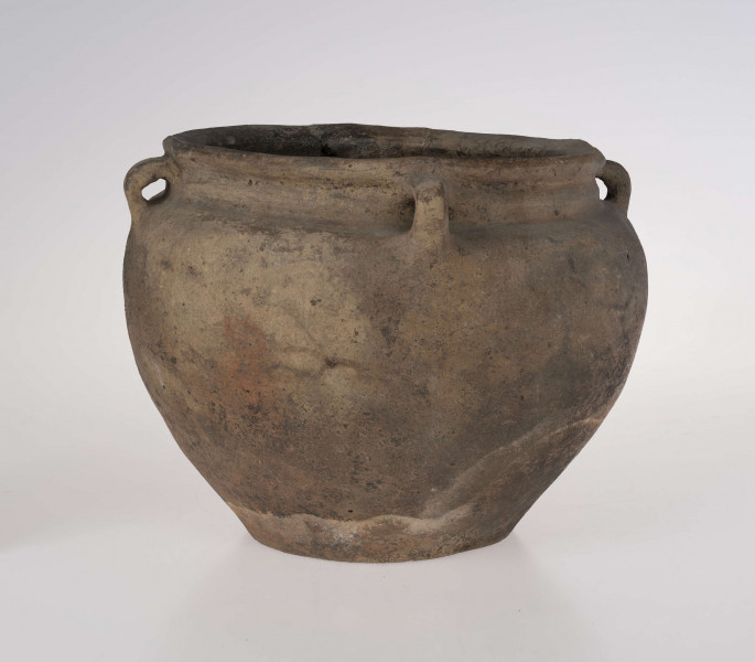 Baniaste naczynie z czterema uszkami o brunatnej powerzchni. Dno niewyodrębnione, delikatnie wklęsłe. Szyjka krótka, cylindryczna.