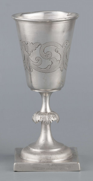 S/Mt/557/ML - Czara koniczna z brzegiem obwiedzionym wałkiem, trzon zdobiony kapturkiem z repusowanym w liście akantu, stopa okrągła z kwadratową plintą. Brzeg stopy karbowany. Na powierzchni czary grawerowany wzór stylizowanej wici roślinnej.
Na brzegu plinty sygnatury wypukłe majuskułą w prostokatnych ramkach:
- J.GAŁECKI
- w LUBLINIE
- punca owalna z przedstawieniem dłoni 
i punca okrągła z oznaczeniem próby 