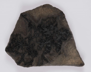 E/397/ML - Klocek wykonany z drewna. Ornament wypukły z mosiężnych blaszek nabitych w drewno, przedstawiający gałązkę winogron. Służy do drukowania tkanin.
