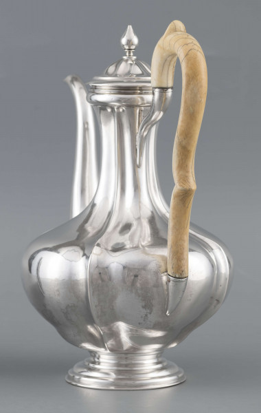 S/Mt/514/ML - Kafetiera w kształcie tralki o brzuscu pękatym i smukłej szyjce, profilowana a żeberkowaniem, na niskiej stopie. Wylew w formie dziobka, ucho kościane z okrągłego wałka, profilowane, osadzone w dwóch tulejkach, pokrywka wysklepiona, z wystającą kryzą i uchwytem w kształcie cebulki. Wnetrze złocone.
Na dnie sygnatura:
- imienna 