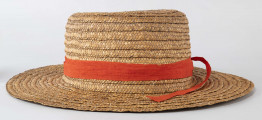 Kapelusz ze słomy owsianej o prostym denku i rondzie płaskim. Upleciony techniką warkoczową. Warkocze bez ząbków, zszyte cienkimi szarymi nićmi. Denko otoczone czerwoną wąską wstążką, zakończone kokardą. 
