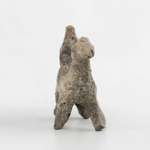 Figurka gliniana jeźdźca na koniu wykonana z wałka glinianego, szyjka wyciagnięta do góry, zwężona, zakończona spłaszczoną głową. Ogon mocno ścieniony, załamany do dołu. Kończyny walcowate, doklejone do korpusu. Postać siedząca na grzbiecie wykonana schematycznie. Surowiec - glina z domieszką piasku. Barwa brunatna. Stan zachowania dobry - drobne ubytki. Zabytek sklejany, uzupełniany gipsem.
Wymiary dodatkowe - 1,9 cm (grub. korpusu); 3 cm (wys. postaci); 1,4 cm (grub. postaci)