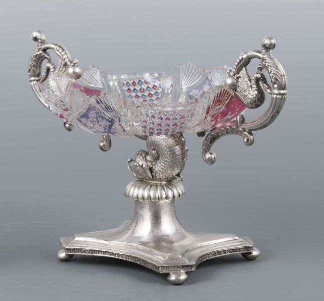 S/Mt/384/ML - Czara ze szkła bezbarwnego, miejscami barwionego powierzchniowo, płytka, owalna, profilowana, z dekoracją szlifowaną (wachlarzyki i szlif brylantowy) i trawioną (wzór kwiatowy) - utrzymana w stylu biedermeier. Umieszczona na figurce delfina z podstawą czworoboczną o wklęsłych bokach i ściętych narożach, z nóżkami w kształcie spłaszczonych kulek. Po bokach czary ucha w formie wolut z liśćmi akantu i motywem łabędzi. Brzeg podstawy obiega pas wici różanej.
Na brzegu podstawy sygnatura wklęsła kursywą: 
-  