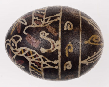 E/1323/ML - Technika batik. Podział poprzeczny na 2 nierówne części. Motyw zwierzęcy (koza, ptaszki) i roślinny. Barwa tła czarna, barwa motywu biała, żółta i ceglasta.