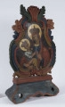 E/16801/ML - Feretron drewniany polichromowany. Z kręgu sztuki prawosławnej. W obramieniu trójlistnym ze stylizowanymi liśćmi akantu, przedstawia Matkę Bożą Chełmską i Św. Mikołaja. 
Madonna z Dzieciątkiem: w niebieskiej szacie ze złotym wykończeniem przy szyi, czerwonym płaszczu, złotej koronie. Na prawym ramieniu trzyma Dzieciątko, w biało-szarej szacie i złotej koronie. Wzrok postaci skierowane ku sobie. Wokół głów – złote nimby. Karnacja cielisto-brązowa. Tło ciemnobrązowe. Po obu stronach głów postaci litery.
Św. Mikołaj: postać stojąca w czerwono-niebieskiej szacie ze złotymi lamowaniami. W lewej, zgiętej w łokciu ręce – księga, brązowa ze złotymi kartami. Prawa ręka zgięta i uniesiona w geście błogosławieństwa; pod nią torba. Na szyi – łańcuch z krzyżem. Na głowie biskupia korona, a wokół niej złoty nimb. Po obu stronach postaci, na wysokości ramion, napisy w j. greckim. W tle pejzaż ze wzniesieniem i roślinnością, a po lewej stronie przedstawienia – cerkiew. 
Kolory obramienia feretronu: ceglasty, czerwony, granatowy, ciemnozielony. 

Konserwacja: 1999-2000
