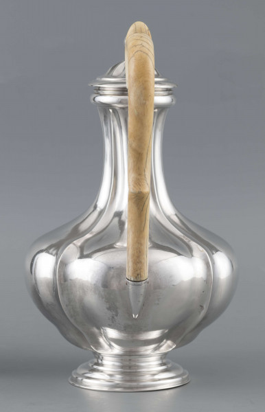 S/Mt/514/ML - Kafetiera w kształcie tralki o brzuscu pękatym i smukłej szyjce, profilowana a żeberkowaniem, na niskiej stopie. Wylew w formie dziobka, ucho kościane z okrągłego wałka, profilowane, osadzone w dwóch tulejkach, pokrywka wysklepiona, z wystającą kryzą i uchwytem w kształcie cebulki. Wnetrze złocone.
Na dnie sygnatura:
- imienna 