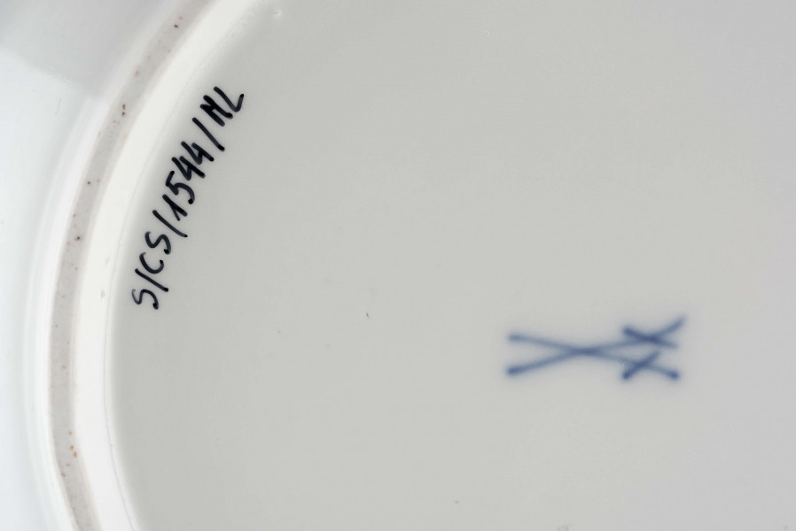 Talerz okrągły o falistym brzegu i pogrubionej krawędzi. Dno płaskie, kołnierz ukośnie odchylony pokryty reliefem plecionkowym z tzw. splotem Sułkowskiego. Dekoracja malarska w stylu Kakiemon rozmieszczona nieregularnie. Na dnie: dwa barwne ptaki (kukułki) siedzące na gałązce, nad nimi kwitnące chryzantemy. Na kołnierzu drobne gałązki kwiatowe na przemian z motylami. Barwy: błękit, czerwień, zieleń, żółcień, brąz i czerń.
 