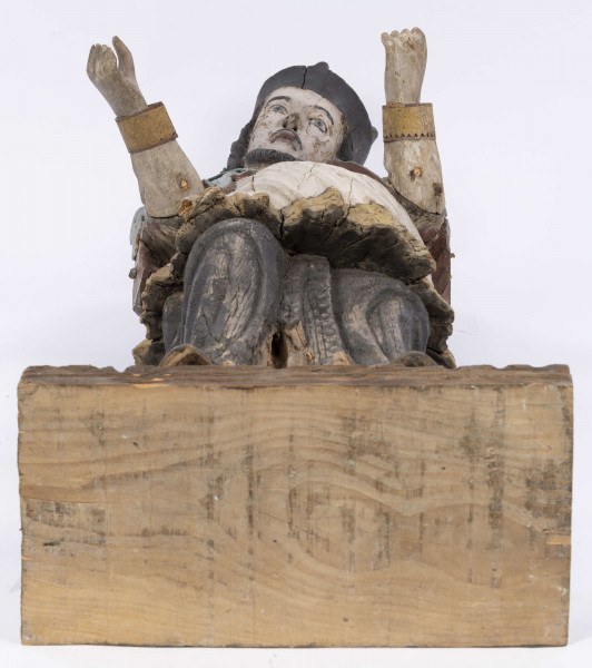 E/8422/ML - Rzeźba drewniana, pełna, polichromowana, przedstawiająca św. Jana Nepomucena. Zakomponowana frontalnie, z rękoma zgiętymi w łokciu i lekko rozłożonymi. Twarz owalna, pomalowana białą farbą. Małą broda i krótkie czarne wąsy. Nos krótki, prosty. Oczy owalne podkreślone czarnym konturem. Brwi łukowate, wąskie, czarne. Włosy czarne, ułożone w pukle. Na głowie czarny biret. Długa czarna sutanna, biała komża ozdobiona u dołu złotą koronką. Na piersiach krzyż, zawieszony na łańcuchu. Na komżę narzucona jasnoniebieska peleryna. Stopy lekko rozstawione. Obuty w sandały o jednym pasku. 

Konserwacja: 1990 r.