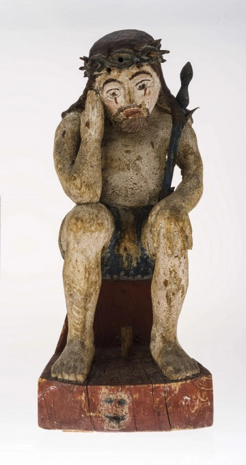 Figura Chrystusa Frasobliwego, wykonana w drewnie lipowym. Korpus pochylony, spoczywa na drewnianej podstawie. Głowa spuszczona, pochylona w prawo. Korona cierniowa opasuje głowę. Włosy gładkie, opadające na ramiona. Twarz szeroka, oczy duże, ślady łez koloru brązowego. Prawa ręka zgięta, dłoń przy policzku.  Lewa ręka z masywną dłonią położona na kolanie. Berło koloru niebieskiego, grot zielony, opiera się o lewe ramię. Perizonium schematycznie zaznaczone, koloru zielono-granatowego. Nogi masywne, stopy na podstawie. Włosy koloru brązowego, korona – granatowego, ciało – szare. Polichromia zniszczona, opisane kolory są jedynie śladami. Podstawa koloru brązowego. Plecy postaci potraktowane gładko.