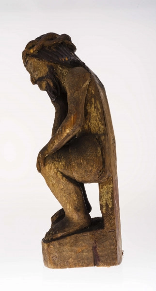 Figura Chrystusa Frasobliwego, pochylona w prawo głowa, wykonana w drewnie lipowym, polichromowana. Twarz potraktowana realistycznie. Korona cierniowa z przeplatanego wałka (kształt ósemki). Ślady cierni. Włosy opadające na ramiona modelowane dość szerokimi podłużnymi żłobieniami. Na włosach ślady polichromii koloru czarnego. Broda koloru brązowego, zaznaczona mocnymi żłobieniami. Prawa dłoń przy policzku. Faktura ciała modelowana gładko. Perizonium krótkie, lekko fałdowane. Prawa stopa na czaszce.