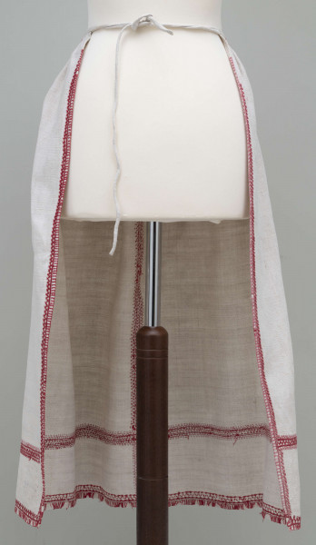 E/7939/ML - Fartuszek lniany zdobiony pośrodku, po bokach i na dole czerwonym haftem, przymarszczony w pasie, wiązany na troczki.