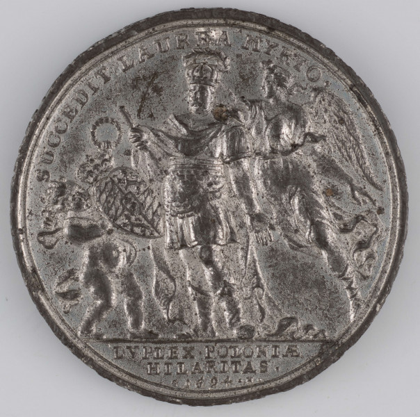 N/1536/ML - AV. Postać króla Jana III Sobieskiego w koronie, w stroju rzymskiego legionisty, z regimentarzem w prawej rece. Victoria lecąca za królem z prawej zdobi go wieńcem. Z lewej barokowe putto trzyma w jednej ręce tarczę z herbami Bawarii, w drugiej wieniec. Na górze w łuku napis:
SUCCEDIT LAUREA MYRTO . 
Na dole w odcinku:
DVPLEX . POLONIAE / HILARITAS . / G 1694 . H . 

RV. Na pierwszym planie tabor ciągnący w stronę twierdzy, przed którą toczy się bitwa. Na górze w półkolu napis:
PRAELVDIA MAIORIS VICTORIAE . 
Na dole w odcinku:
FVSIS HOSTIBVS / COMEATV INTER = / CEPTO .
Na obrzeżu napis poprzedzony rozetką:
* T[R]IBVAT TIBI SECVNDVM COR TVVM ET OMNE CONSILIVM TVVM CONFIRMET . PS . XIX . V . 4 .