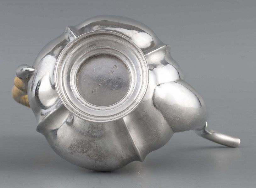 S/Mt/514/ML - Kafetiera w kształcie tralki o brzuscu pękatym i smukłej szyjce, profilowana a żeberkowaniem, na niskiej stopie. Wylew w formie dziobka, ucho kościane z okrągłego wałka, profilowane, osadzone w dwóch tulejkach, pokrywka wysklepiona, z wystającą kryzą i uchwytem w kształcie cebulki. Wnetrze złocone.
Na dnie sygnatura:
- imienna 