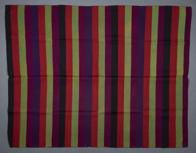 E/6798/ML - Tkanina pasiak, tkana splotem rządkowym. Osnowa lniana czarna, wątek wełniany w kolorach:  czerwony, buraczkowym, zielonym, czarnym i granatowym. Raport tworzą pasy o szer. 6,5 cm. 