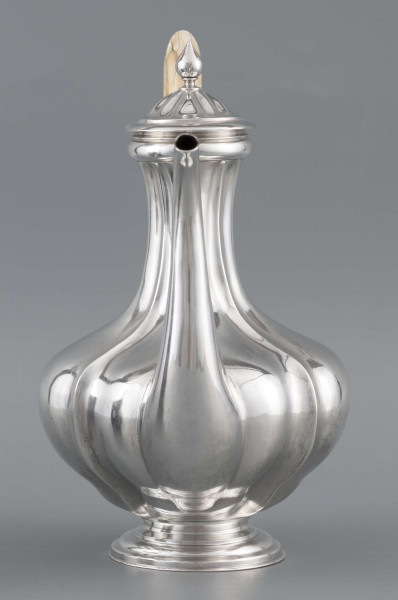 S/Mt/514/ML - Kafetiera w kształcie tralki o brzuscu pękatym i smukłej szyjce, profilowana a żeberkowaniem, na niskiej stopie. Wylew w formie dziobka, ucho kościane z okrągłego wałka, profilowane, osadzone w dwóch tulejkach, pokrywka wysklepiona, z wystającą kryzą i uchwytem w kształcie cebulki. Wnetrze złocone.
Na dnie sygnatura:
- imienna 