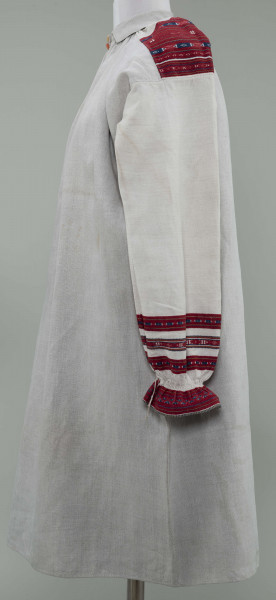 Koszula lniana o kroju przyramkowym, marszczonym. Ozdobiona na przyramkach i mankietach pereborami w kolorze czerwonym, granatowym i żółtym. Mankiety falbankami.