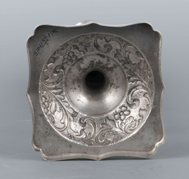 S/Mt/501/ML - Stopa okrągła nacokoliku kwadratowym z profilowanym brzegiem, trzon tralkowaty z talerzykiem i dwoma kołnierzami, tulejka w kształcie kielicha. Na brzegu stopy, kołnierzykach i w górnej części trzonu moletowany wzór wici roślinnej z kwiatami -  ornamenty polerowanę na zmatowionym tle. Na talerzyku wzór lancetowatych liści. 
Na boku cokolika słabo czytelna sygnatura majuskułą w prostokątach:
- I.SZTERN
- dodatkowy znak warsztatowy w postaci cyrklowej rozetki
- znak probierni warszawskiej z monogramem probierza 