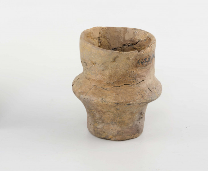 Pucharek ulwówecki; dno małe, płaskie; nóżka wysoka; brzusiec ostro załamany; szyjka wysoka, cylindryczna; powierzchnie gładzone, spękane; krawędź zaokrąglona
wymiary dodatkowe: 3,5 cm (śr. dna); 2,6 cm (wys. szyi); 2,0 cm (wys. nóżki). Surowiec - glina z domieszką drobnoziarnistego tłucznia. Barwa obustronnie pomarańczowa w ciemne plamy. przełom brunatny. Brak części szyi, uzupełnione gipsem.