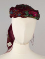 E/516/ML - Czepek mężatki. Denko wewnętrzne wykonane z plecionej siatki zielonej. Z wierzchu chustka fabryczna koloru ciemnoczerwonego w kwiaty wiązana na tekturowej obręczy. Końce chustki zwisają do tyłu.