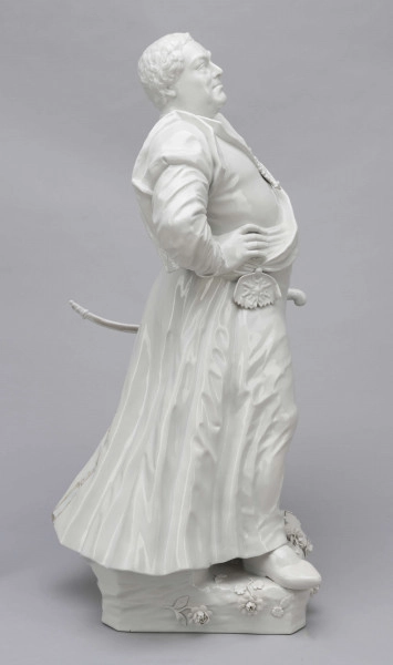 S/CS/657/ML - Figura z białej porcelany przedstawia króla Augusta III en pied na cokole zdobionym plastycznie modelowanymi różami i goździkami. Król stoi w kontrapoście, z lekko uniesioną głową, prawą rękę opiera na biodrze, w lewej opuszczonej trzyma czapkę okrągłą obszytą futrem. Ubrany jest w polski strój szlachecki: żupan, kontusz z zarzuconymi wylotami i pas. Na piersi ma order Złotego Runa i wstęgę z krzyżem orderu Orła Białego, przy lewym boku szablę na ozdobnych rapciach.
Figura stanowi wierne odwzorowanie portretu króla wykonanego przez Louis de Silvestre'a nadwornego malarza ok. roku 1737 (obecnie w zbiorach Muzeum w Wilanowie).