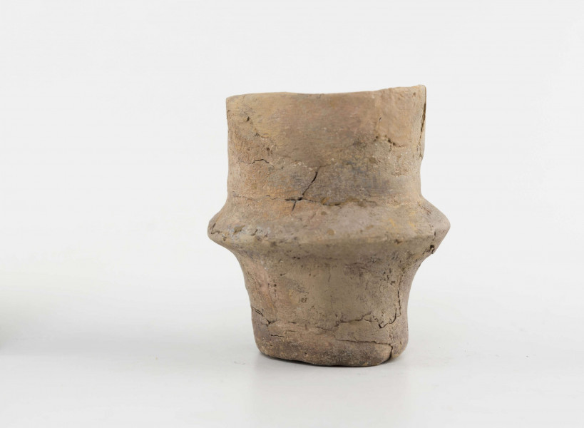 Pucharek ulwówecki; dno małe, płaskie; nóżka wysoka; brzusiec ostro załamany; szyjka wysoka, cylindryczna; powierzchnie gładzone, spękane; krawędź zaokrąglona
wymiary dodatkowe: 3,5 cm (śr. dna); 2,6 cm (wys. szyi); 2,0 cm (wys. nóżki). Surowiec - glina z domieszką drobnoziarnistego tłucznia. Barwa obustronnie pomarańczowa w ciemne plamy. przełom brunatny. Brak części szyi, uzupełnione gipsem.